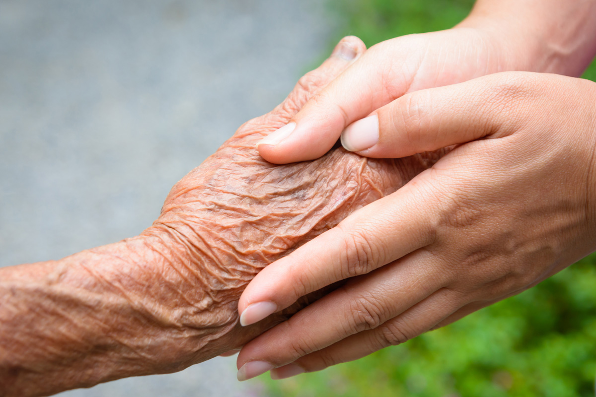Senior and young holding hands
